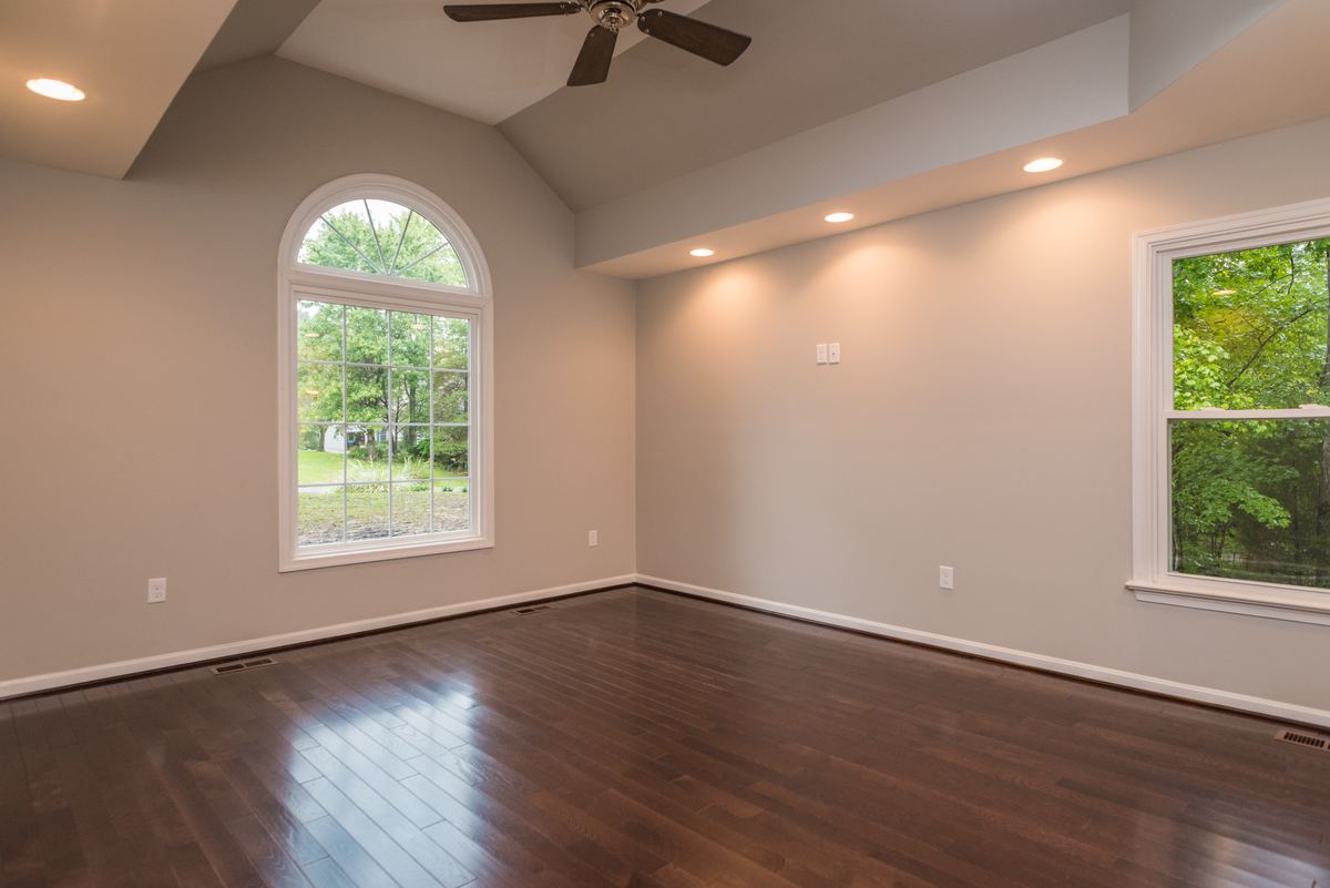 Finished interior with hardwood flooring and an arched feature window