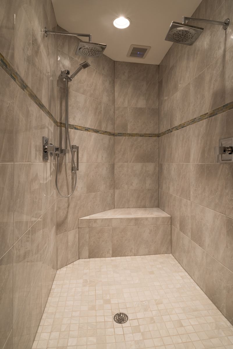 Full tiled walk-in shower with bench seat and dual shower heads